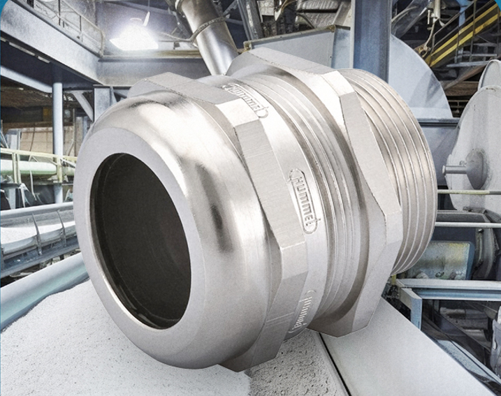 Close-up of a large stainless steel pipe flange and grooved coupling in an industrial plant.