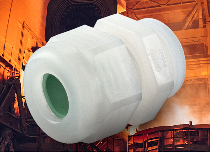 Large white plastic pipe coupling in an industrial setting with orange-lit background, green interior visible inside the bore.