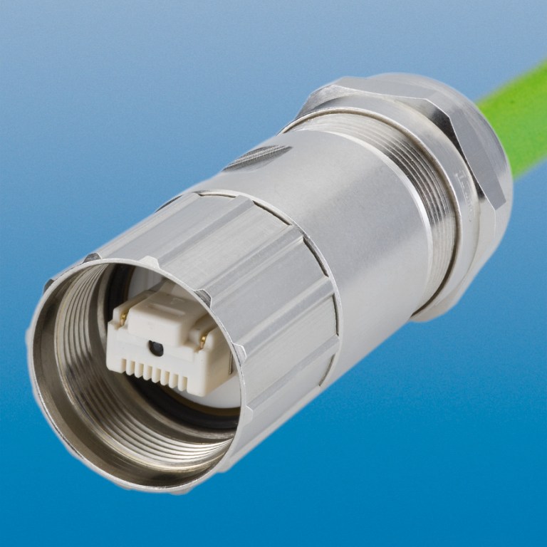 Close-up of a metal circular electrical connector with a white plastic insert and threaded coupling, attached to a green cable.